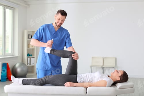 Preview: Physiotherapist working with female patient in clinic