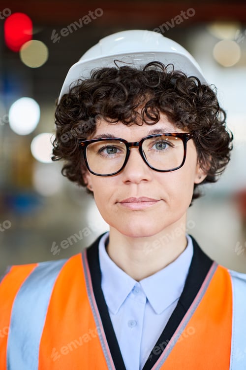 Preview: Young female factory worker with short dark curly hair wearing uniform