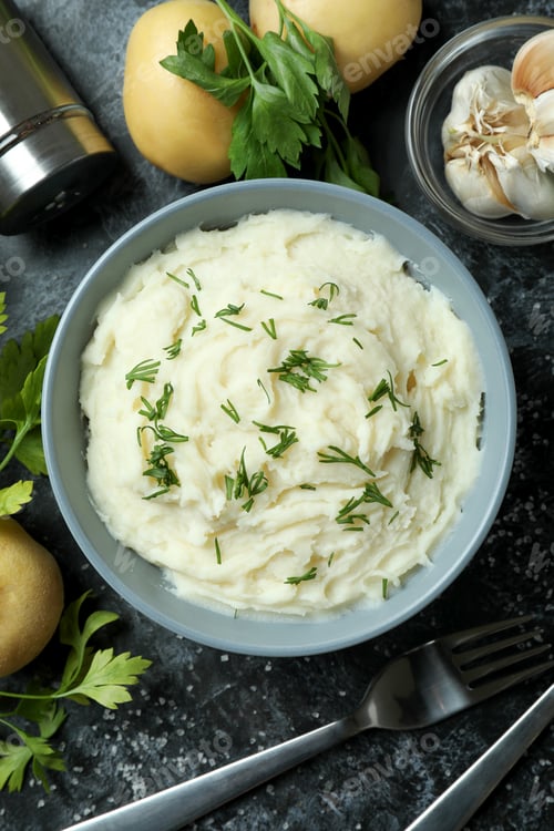 Preview: Concept of tasty eating with mashed potatoes on black smokey table