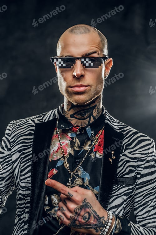 Preview: Fashionable tattooed male model posing in a studio