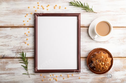 Preview: Brown wooden frame mockup with cup of coffee and cake on white wooden background. top view