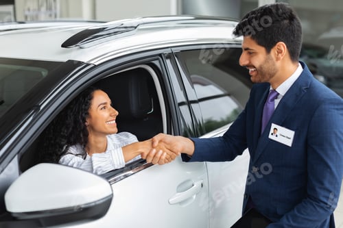 Preview: Happy business woman buying new luxury auto in showroom