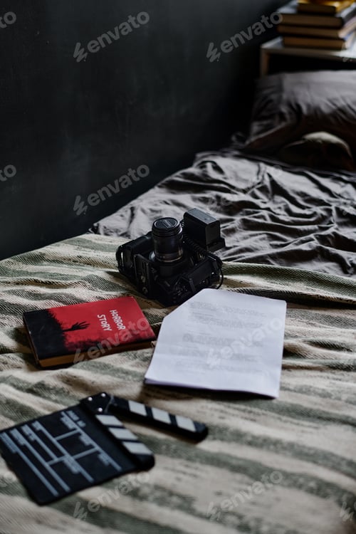 Preview: Camera, Books, and Documents Arranged on Bed