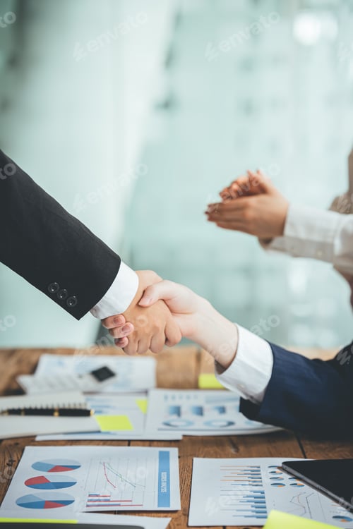 Visualização: Glad to work with you! Fashionable young man in smart casual wear holding hands and smiling while wo
