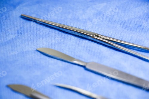 Preview: Closeup of a stainless dissection kit on a blue surface