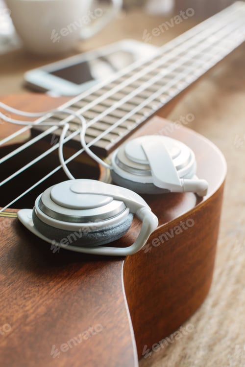 Preview: Ukulele guitar with earphone on wooden table