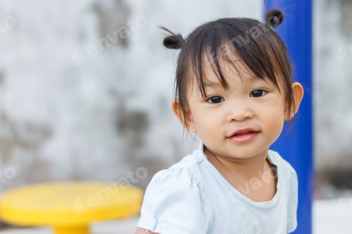 Preview: Portrait of Asian child baby cute girl smiling with happy face. At the park playground.