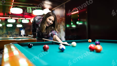 Preview: Young smiling girl playing billiard in club