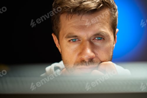 Preview: Tired man looking at computer screen at night