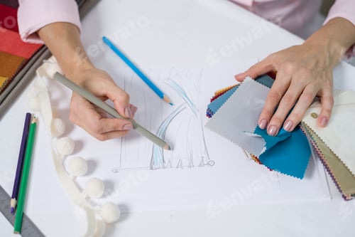 Preview: Woman textile interior designer working with fabric samples drawing curtains sketch