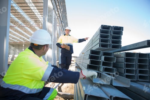 Preview: Builder and site manager checking girders on construction site