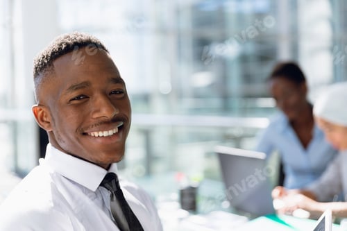 Preview: Happy Businessman sitting at desk in office