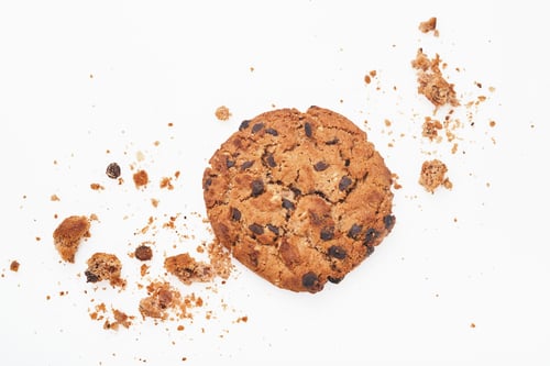 Preview: Stack of chocolate chip cookies and crumbs on white background. Top view.