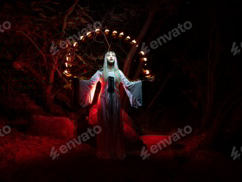 Preview: A woman sitting on a rock in the forest and dressed in a tunic, throws red lights from her hands.