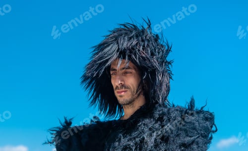 Preview: A Georgian man in a hat against the background of mountains and the sky. Selective focus.