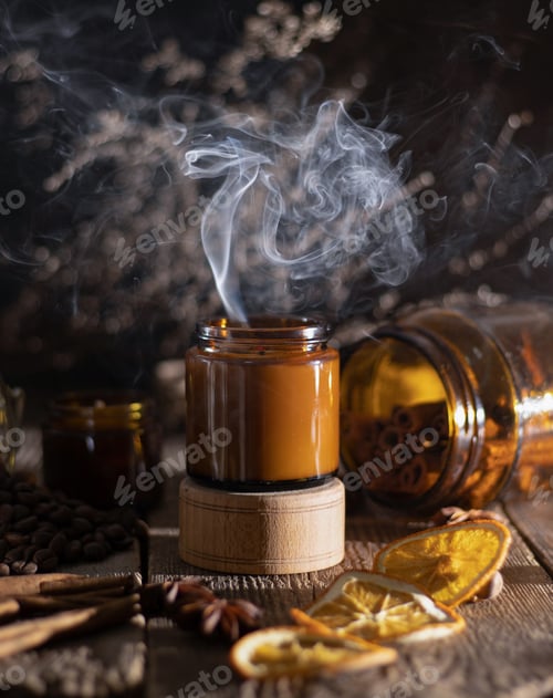 Visualização: Vela de aroma em uma jarra de vidro marrom. Velas perfumadas acesas. Cheiro e especiarias e fumaça.
