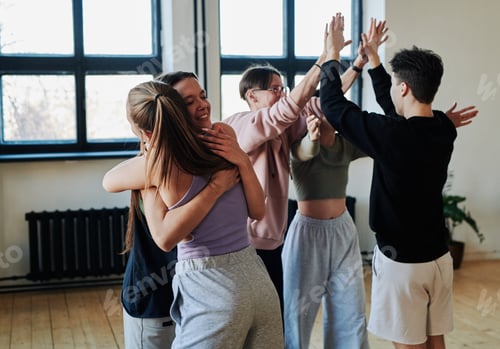 Preview: Group of contemporary teenage friends giving hugs and high five to each other