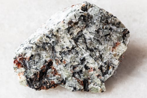 Preview: sample of raw foyaite rock on white marble