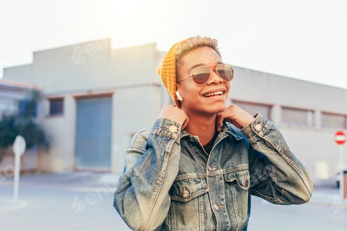 Preview: Young smiling afro boy listens music outdoors