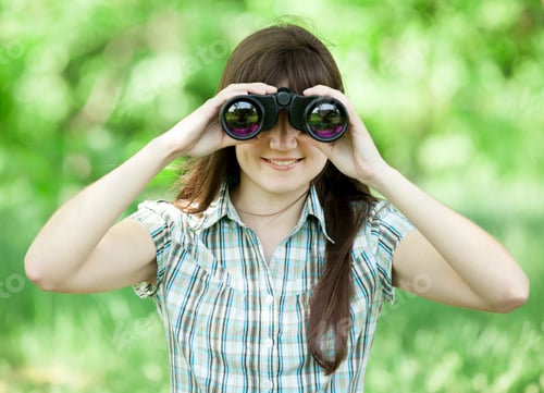 Preview: Teen girl with binocular at green grass