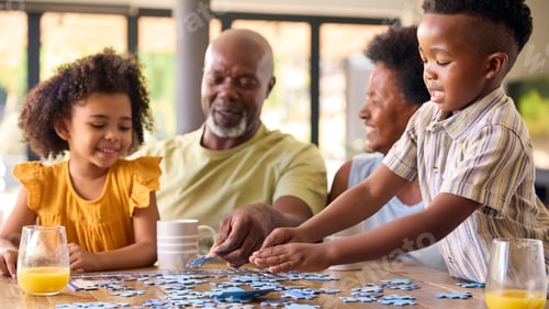 Preview: Family Shot With Grandparents And Grandchildren Doing Jigsaw Puzzle On Table At Home
