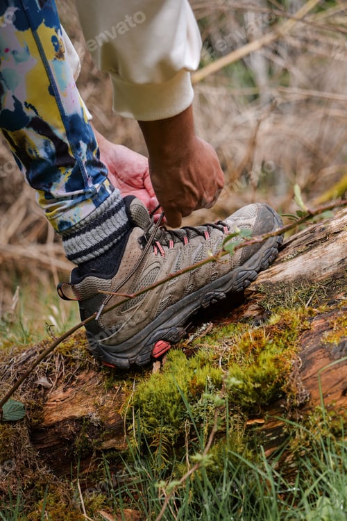 Preview: Tying hiking boots on a mossy log