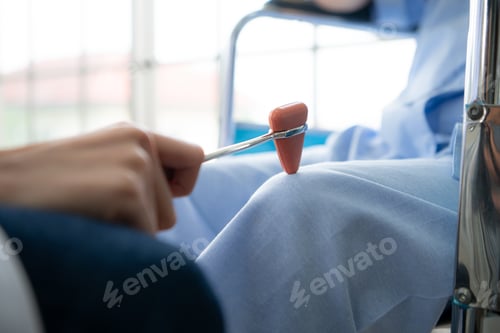 Preview: A doctor uses a reflex hammer to evaluate a patient's knee joint