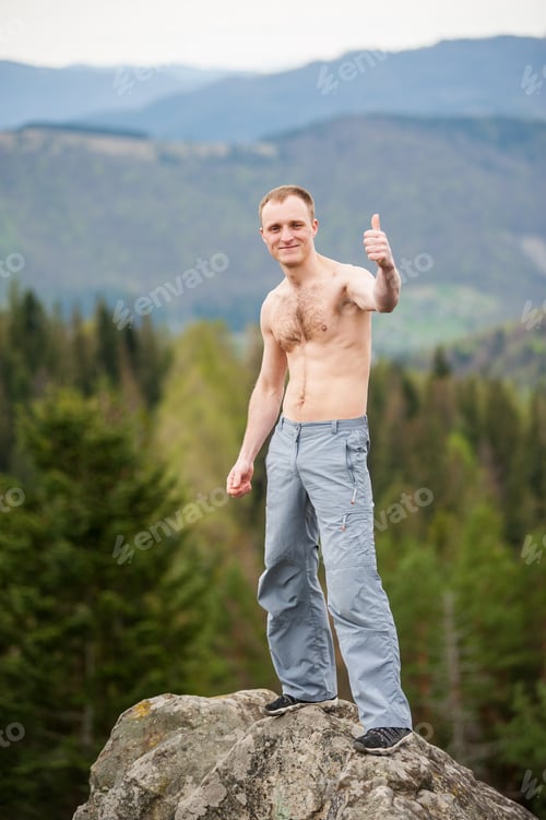 Preview: Male climber with brown backpack on the peak of rock
