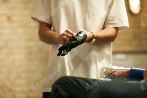Preview: Hairdresser in barbershop putting on latex glove