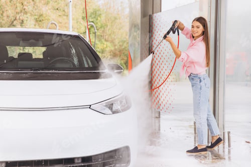 Preview: Young Woman Cleaning Her Car at Self-Service Car Wash