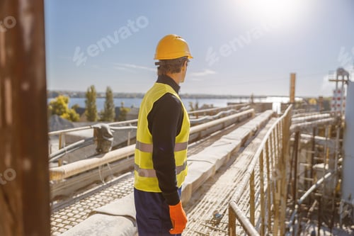 Preview: Male worker standing outdoors at industrial site