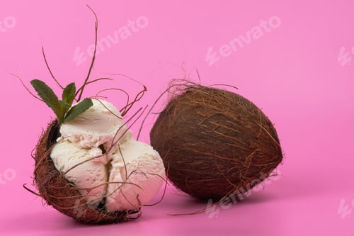 Preview: Vanilla ice cream balls in an empty coconut decorated with mint leaves on a pink background