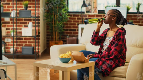 Preview: Cheerful adult enjoying hamburger from food delivery
