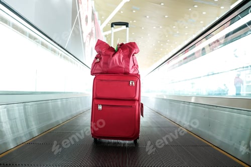 Preview: Travel luggage on walkalator in an airport terminal building.