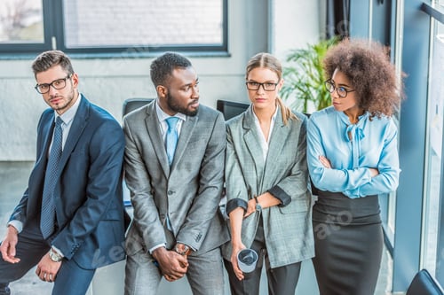 Preview: multicultural businesspeople leaning on table in office