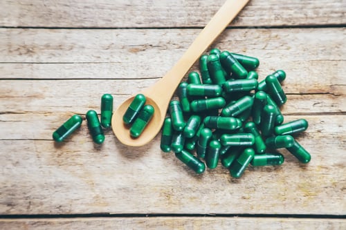 Preview: Green capsules, herbal medicines. Buds. Selective focus.