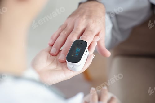 Preview: Doctor Helping Patient to Put On Pulse Oximeter