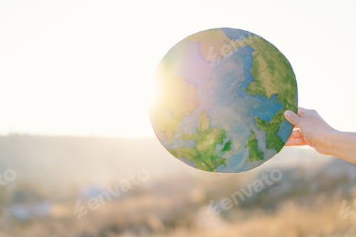 Preview: Woman holding planet in hands against green spring background. Earth day