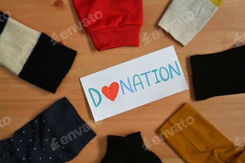 Preview: Carton boxes with clothes on wooden table. Charity, donation and reuse recycle concept.