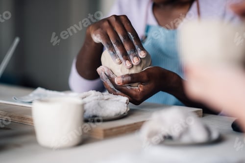 Preview: Cropped picture of interracial craftswoman's hands making earthenware