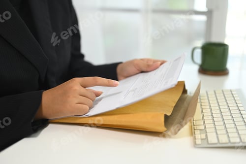 Preview: Close up of businesswoman analyzing important documents at desk