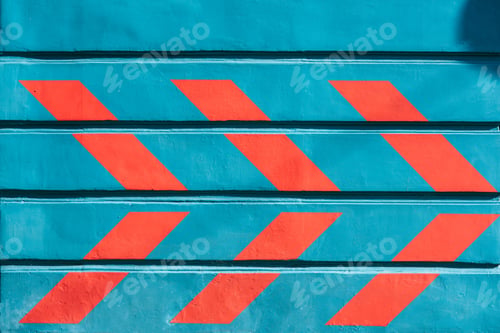 Preview: close-up view of red arrows drawn on blue wall outside