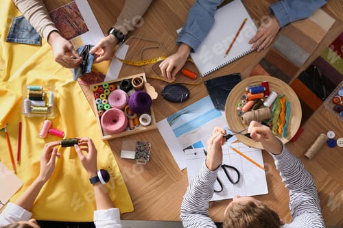 Preview: Fashion designer creating new clothes in studio, top view