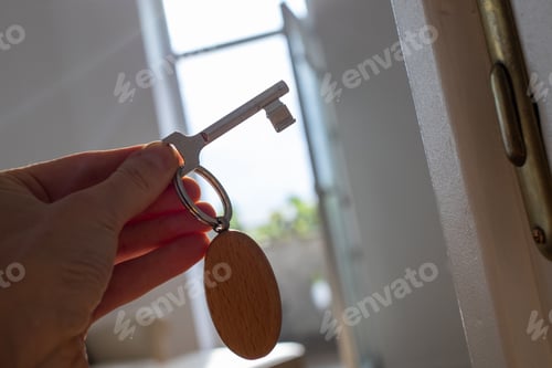 Preview: key opening white door to a modern home