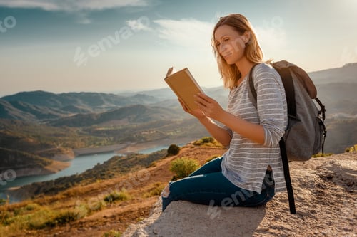 Preview: Woman Reading Book on Mountain Overlooking Lake