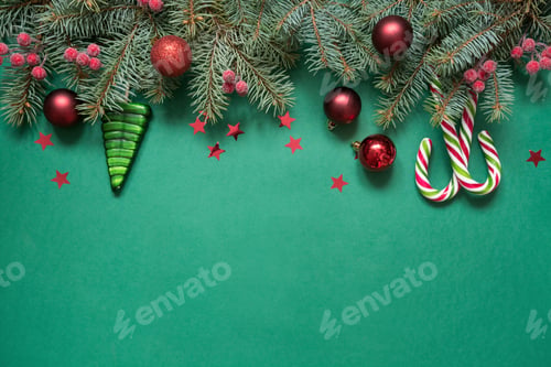 Preview: Christmas tree branches, red glass balls on green with copy space. Top view. Holiday card.