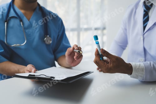 Preview: Medical or scientific researchers analyzing and discussing test tubes of laboratory solutions for bi