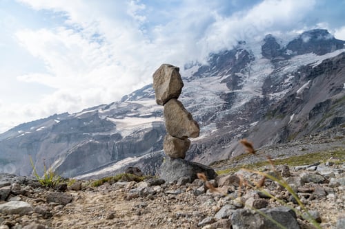 Preview: Mountain Cairn on Mount Rainier hiking trail with stormy sky.