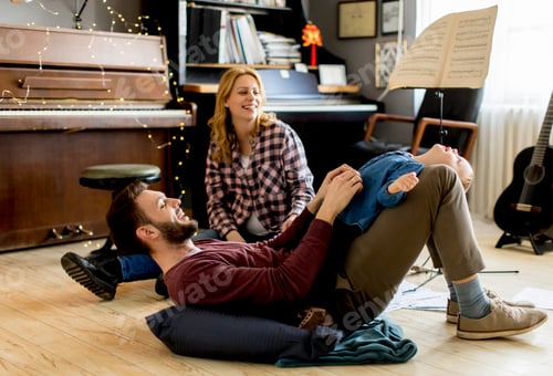 Preview: Happy young family playing on the floor