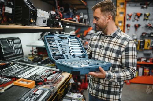 Preview: A male buyer chooses a toolbox in a hardware store. A large selection of tools.
